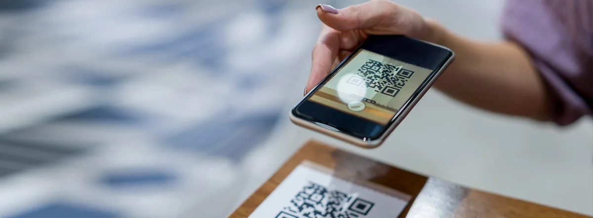 Person scanning a printed QR code with a smartphone